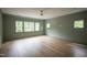 Spacious bedroom with multiple windows, hardwood floors, and a ceiling fan at 7932 Wexford Waters Ln, Wake Forest, NC 27587