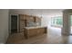 Open-concept living area with a kitchen island, modern cabinets, and sliding glass doors at 7932 Wexford Waters Ln, Wake Forest, NC 27587