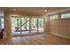 Open-concept living room with hardwood floors and sliding glass doors to the patio at 7932 Wexford Waters Ln, Wake Forest, NC 27587