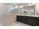 Modern bathroom featuring dual vanities, a glass-enclosed shower, and neutral tile work at 87 Addison Pond Ct # 12, Zebulon, NC 27597