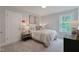 Comfortable bedroom with a window, bedside table, and light neutral decor at 87 Addison Pond Ct # 12, Zebulon, NC 27597