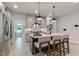 Well-lit kitchen island with a sink, barstool seating, pendant lights, and white cabinets with stainless appliances at 87 Addison Pond Ct # 12, Zebulon, NC 27597