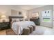 Well-lit main bedroom with a gray headboard, neutral bedding, and coordinated side tables, creating a relaxing space at 87 Addison Pond Ct # 12, Zebulon, NC 27597