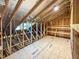 Bright attic space showcasing exposed beams and plywood flooring for potential finishing or versatile use at 87 Addison Pond Ct, Zebulon, NC 27597