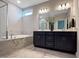 Bright bathroom featuring a double vanity, soaking tub and walk-in shower with marble surround at 87 Addison Pond Ct, Zebulon, NC 27597