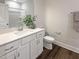 Bathroom vanity with white cabinets, granite countertop, sink, and new fixtures. A door to the left at 87 Addison Pond Ct, Zebulon, NC 27597