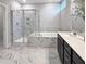 A bright bathroom features marble flooring and a tiled shower and bathtub with white countertops at 87 Addison Pond Ct, Zebulon, NC 27597