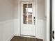 Bright entryway featuring a white door with glass panels and paneled walls at 87 Addison Pond Ct, Zebulon, NC 27597