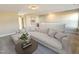 Bright living room features a comfortable sectional sofa, round coffee table, and neutral color palette at 87 Addison Pond Ct, Zebulon, NC 27597