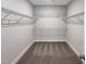 Empty walk-in closet with metal shelving, carpeted flooring, and a blank canvas for organization at 87 Addison Pond Ct, Zebulon, NC 27597