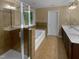 Bright bathroom featuring a shower, soaking tub with tiled surround, and double vanity sinks at 8844 Forester Ln, Apex, NC 27539