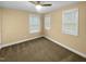 A bedroom with a ceiling fan and two windows bringing in natural light at 8844 Forester Ln, Apex, NC 27539