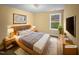 Staged bedroom with natural light featuring a queen-sized bed and matching nightstands on top of a neutral rug at 8844 Forester Ln, Apex, NC 27539