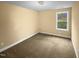 Bright, empty bedroom with a large window providing plenty of natural light and neutral carpeting at 8844 Forester Ln, Apex, NC 27539