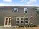Back exterior of a home with gray siding, a small patio, and lots of bright windows for natural light at 8844 Forester Ln, Apex, NC 27539