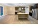 Open-concept kitchen with a center island, dark wood cabinets, stainless steel appliances, and hardwood floors at 8844 Forester Ln, Apex, NC 27539