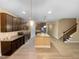 Open-concept kitchen with dark wood cabinets, stainless steel appliances, granite countertops, and a center island at 8844 Forester Ln, Apex, NC 27539