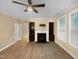 Bright living room featuring a fireplace with built-in shelving, a modern ceiling fan, and sleek hardwood floors at 8844 Forester Ln, Apex, NC 27539