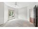 Bright bedroom with a ceiling fan, light-colored carpet, and natural light from a large window at 1000 Brighthurst Dr # 104, Raleigh, NC 27605