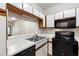 Kitchen featuring modern appliances, white cabinets, and ample counter space at 1000 Brighthurst Dr # 104, Raleigh, NC 27605