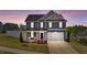 Charming two-story home with blue siding and a manicured front yard at dusk at 1002 Addington Lake Ln, Knightdale, NC 27545