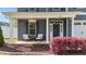 Inviting front porch with chairs, hanging planters, and colorful landscaping at 1002 Addington Lake Ln, Knightdale, NC 27545