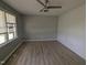 Bright bedroom featuring light gray walls, laminate wood flooring, and a ceiling fan at 1064 Abbott Rd, Henderson, NC 27537