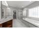 Bathroom featuring a glass enclosed shower, garden tub, marble floors, and double vanities at 12217 Beestone Ln, Raleigh, NC 27614