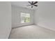 Bright bedroom with neutral carpet, ceiling fan, and view of the backyard at 12217 Beestone Ln, Raleigh, NC 27614