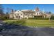 Elegant clubhouse with a circular driveway, pristine lawn, and architectural details, offering a luxurious ambiance at 12217 Beestone Ln, Raleigh, NC 27614