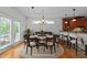 Formal dining area featuring a round table set for dinner and adjacent kitchen with bar seating at 12217 Beestone Ln, Raleigh, NC 27614