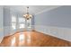 Dining room featuring hardwood floors, wainscoting, bay window and an elegant chandelier at 12217 Beestone Ln, Raleigh, NC 27614