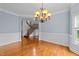 Bright, airy dining room with wainscoting, hardwood floors, decorative chandelier, and stairway view at 12217 Beestone Ln, Raleigh, NC 27614