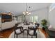 Elegant dining room with marble table, chandelier and an open view into the living room with fireplace at 12217 Beestone Ln, Raleigh, NC 27614