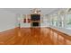 Spacious living room featuring a stone fireplace, built-in shelving, and gleaming hardwood floors at 12217 Beestone Ln, Raleigh, NC 27614