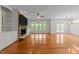 Bright living room with hardwood floors, a stone fireplace, built-in shelving, and views of the backyard at 12217 Beestone Ln, Raleigh, NC 27614