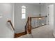Staircase featuring hardwood and carpeted steps, a wooden railing, and a window at 12217 Beestone Ln, Raleigh, NC 27614
