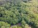 An aerial view of a tree-covered neighborhood, showing the density of the trees and the area at 12709 Timberlane Ct, Raleigh, NC 27613