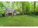A well-maintained backyard featuring a screened porch and a cozy fire pit area surrounded by mature trees at 12709 Timberlane Ct, Raleigh, NC 27613