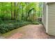 Brick patio and landscaped backyard with lush greenery and mature trees at 12709 Timberlane Ct, Raleigh, NC 27613