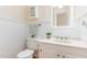Well-lit bathroom featuring a white vanity, beadboard walls, and neutral decor at 12709 Timberlane Ct, Raleigh, NC 27613