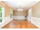 Bright dining room with hardwood floors, white trim, and a stylish chandelier at 12709 Timberlane Ct, Raleigh, NC 27613