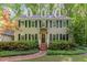Classic two-story home with black shutters, dormer windows, surrounded by lush greenery and mature trees at 12709 Timberlane Ct, Raleigh, NC 27613