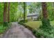 Charming two-story home with black shutters, surrounded by lush greenery and a long driveway at 12709 Timberlane Ct, Raleigh, NC 27613