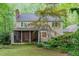 Back exterior featuring a screened-in porch and patio, surrounded by mature trees and landscaping at 12709 Timberlane Ct, Raleigh, NC 27613