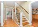 Hallway with wood floors and a staircase, leading to rooms filled with natural light at 12709 Timberlane Ct, Raleigh, NC 27613