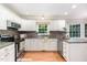 Bright kitchen featuring white cabinets, gray countertops, stainless steel appliances, and natural lighting at 12709 Timberlane Ct, Raleigh, NC 27613