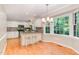 Eat-in kitchen with white cabinetry, barstool seating, and a large window overlooking greenery at 12709 Timberlane Ct, Raleigh, NC 27613