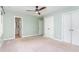 Airy main bedroom with double closets and carpet floors leading to a bathroom at 12709 Timberlane Ct, Raleigh, NC 27613