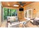 Cozy screened-in porch with wood paneling, comfortable seating, and a view of the backyard at 12709 Timberlane Ct, Raleigh, NC 27613